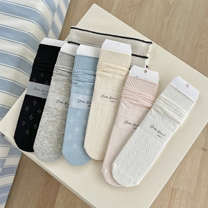 Detail of 6-pack hollow knit crew socks in assorted pastel colors with paper tags