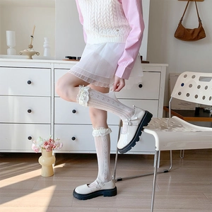Dettaglio calzini bianchi in pizzo a cuore con scarpe Mary Jane con plateau