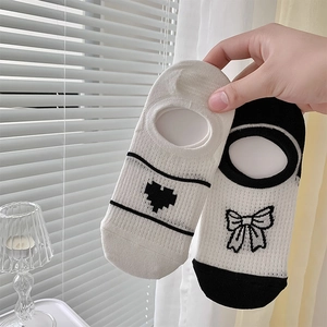 Gros plan de chaussettes basses pour femmes avec broderie cœur et nœud et silicone antidérapant