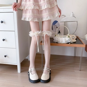 Detail of white fishnet stockings with lace frills and ribbon bows in Lolita style
