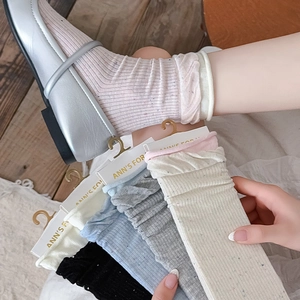 Close-up of colorful speckled cotton socks with ruffled cuffs in various soft colors