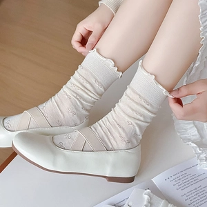 Détail de chaussettes style ballet avec motif nœud, bord à volants et souliers Mary Jane