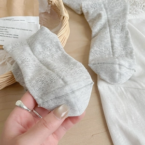 Detail of light gray mesh knit socks with lace hollow pattern and breathable texture