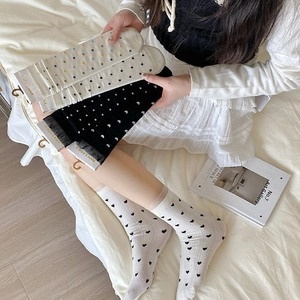 Détails de chaussettes douces avec dentelle, motifs de cœurs et pois colorés