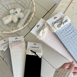 Detail of lace trim and bowknot on breathable socks in black, white, and pastels