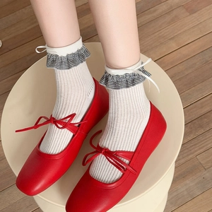 Détail de ballerines à nœuds avec chaussettes à bord volanté à carreaux en vitrine
