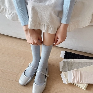 Gros plan de chaussettes style ballet avec jacquard à nœuds et bords à volants doux