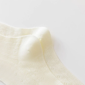 Detailed macro view of cream white breathable mesh knit fabric on these ankle socks