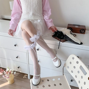 Close-up of white lace mesh knee-high socks with delicate silk bow and ruffle detail