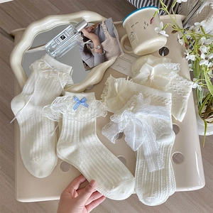 Détail de chaussettes Lolita blanc crème avec bordure en dentelle et nœuds à carreaux
