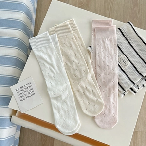 Detail of hollow dot pattern socks in white beige and pink with ribbed cuffs