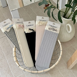 Detail of knit striped socks with lace trim and bow knot in various pastel colors