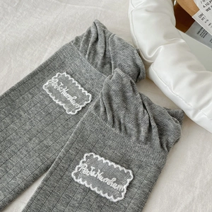 Detail of grey knitted socks with white lace embroidery and ribbed texture fabric