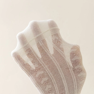 Close-up of white heart mesh socks showing breathable hollow-out lace texture