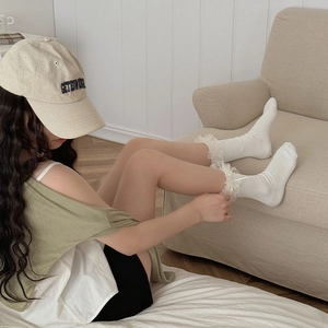 Détail de chaussettes en coton blanc avec bordure en dentelle et petit nœud ruban