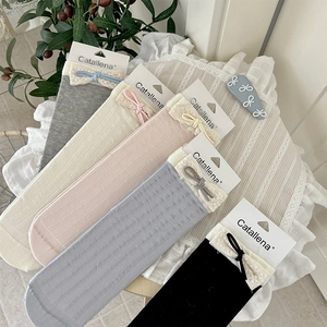 Detail of five pairs of ribbed socks with lace trim and cute bows in soft pastel colors