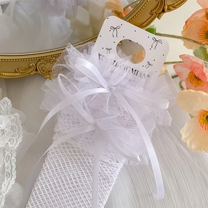 Detail of white mesh lace socks featuring ruffled edges and elegant satin bows