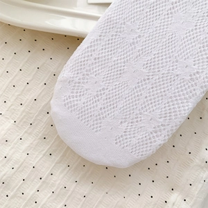Detailed macro shot of white lace floral mesh socks showing breathable hollow patterns