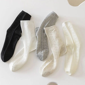 Detail view of five assorted crew socks with delicate hollowed-out diamond knit patterns