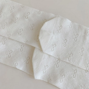 Gros plan de chaussettes blanches en maille respirante avec motifs de nœuds brodés