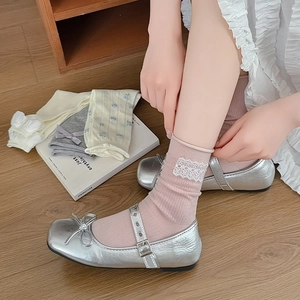 Detailed side view of pink knit socks featuring delicate white lace floral appliques