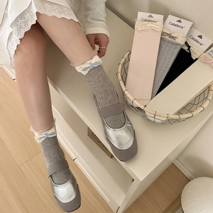Detail of four pairs of lace-trim mid-calf socks with bows in gray, pink, black, and beige