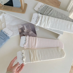 Détails de motif nœud et bordure ondulée sur chaussettes en coton aux tons pastel