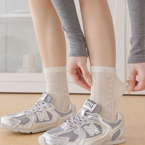 Close-up of white breathable mesh socks with heart patterns and ribbed cuffs