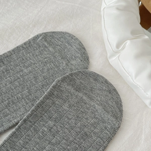 Close-up of soft grey mélange cotton knit fabric texture on a sweet lace style sock