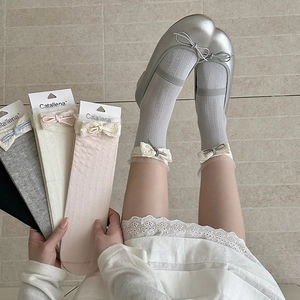 Detail of lace trim and ribbon bows on ribbed cotton crew socks in multiple colors