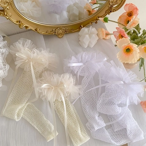 Detailed close-up of lace mesh socks featuring delicate bow ribbons in white and beige