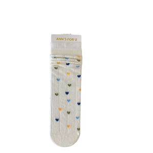 Chaussettes blanches en dentelle avec petits cœurs colorés et maille torsadée
