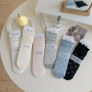 Détail de 6 paires de chaussettes en coton pastel avec motifs nœuds et volants