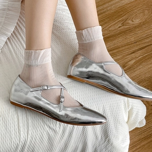 Nahaufnahme von silbernen Mary Jane flachen Schuhen mit Riemen und weißen Spitzen-Socken