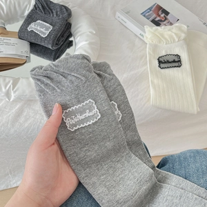Detail of lace ruffled cuff socks with ReteHumhum embroidery label in soft cotton