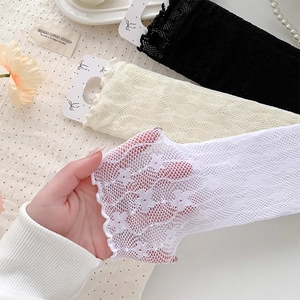 Detail of floral lace mesh socks with ruffled cuffs in black, cream, and white colors