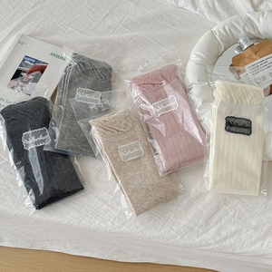 Close-up of ribbed cotton crew socks in five neutral colors with elegant lace trim