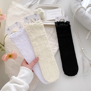 Detailed macro view of lace mesh socks with frilly edges and delicate floral patterns