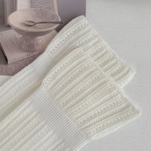 Détail de chaussettes en maille ajourée blanche avec rayures verticales et dentelle