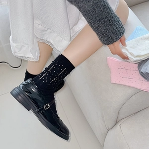 Detailed view of women socks with sparkling rhinestones and elastic knitted cotton texture