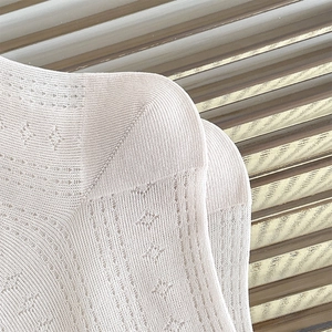 Makro-Detail des atmungsaktiven Hohlstrickmusters weißer Netzstrümpfe für Damen