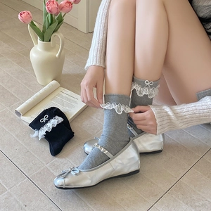 Sweet mid-calf socks with delicate lace trim and ribbon bow details in a flat lay view