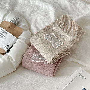 Detail of knit cotton socks with lace edge and Petite Hamster embroidered label