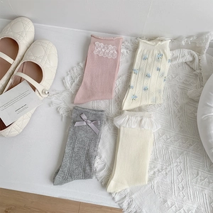 Flat lay of gray bow and floral lace ankle socks in various cute Japanese styles