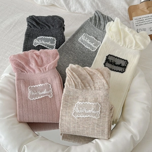Detail of ruffled lace trim and sweet letter patch on Japanese style cotton socks