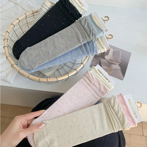 Detailed close-up of colorful flecked knit socks in various pastel and neutral tones