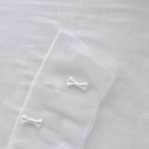 Detailed view of white mesh socks with delicate silk ribbon bows in sweet Lolita style