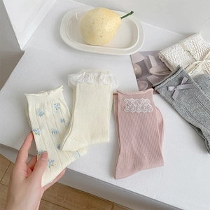 Flat lay of four sets of women's socks with floral patterns and bow details