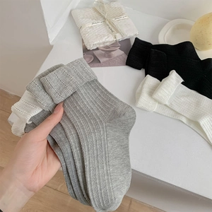 Détail de chaussettes en maille côtelée douce grise, noire et blanche avec texture respirante