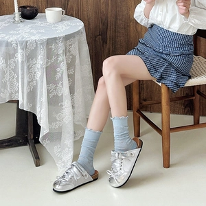 Silver metallic mule shoes with satin bow decoration paired with light blue ruffled socks